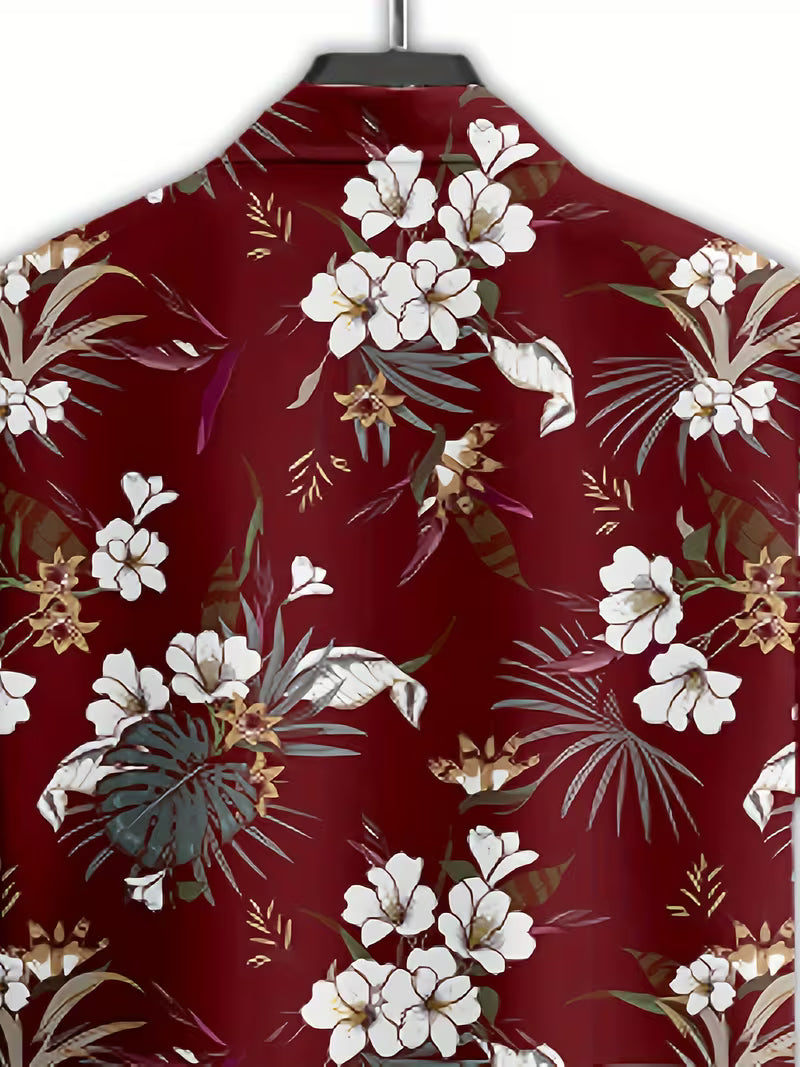 A close-up of a red button-up shirt on a hanger, featuring a tropical floral print with white flowers, green palm leaves, and gold accents.
