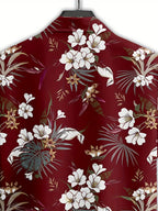 A close-up of a red button-up shirt on a hanger, featuring a tropical floral print with white flowers, green palm leaves, and gold accents.