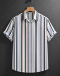 A short-sleeve button-up shirt with vertical stripes in black, white, blue, and brown, hanging on a wooden hanger against a dark gray textured background.