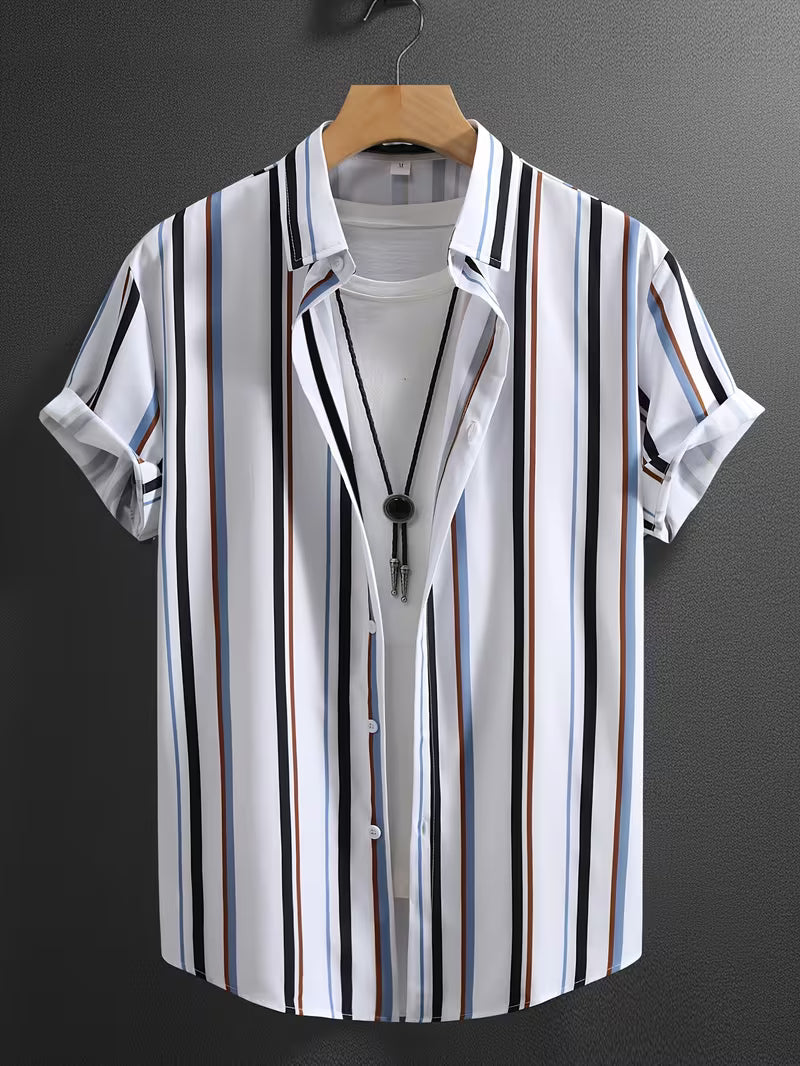 A men's short-sleeve button-up shirt with vertical stripes in black, white, blue, and brown, styled open over a white t-shirt on a wooden hanger against a dark gray wall.
