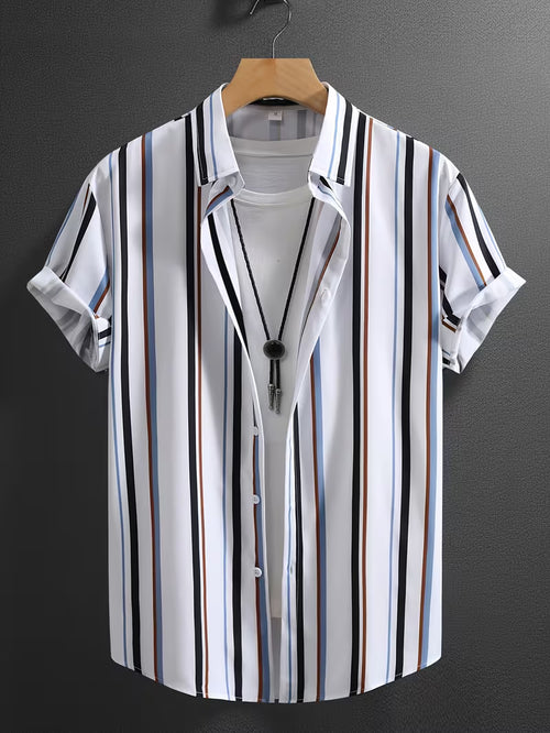 A men's short-sleeve button-up shirt with vertical stripes in black, white, blue, and brown, styled open over a white t-shirt on a wooden hanger against a dark gray wall.