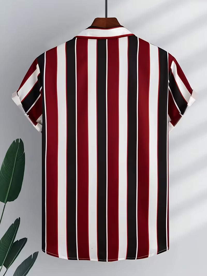 A short-sleeve collared shirt hanging on a wooden hanger, featuring bold vertical stripes in red, black, and white. The shirt is displayed against a light gray background with soft leaf shadows and a decorative green plant leaf on the left.