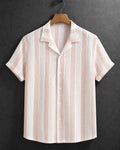 A short-sleeve button-up shirt with vertical stripes in light pink and off-white, featuring a textured woven pattern. The shirt is displayed on a wooden hanger against a dark gray textured background.