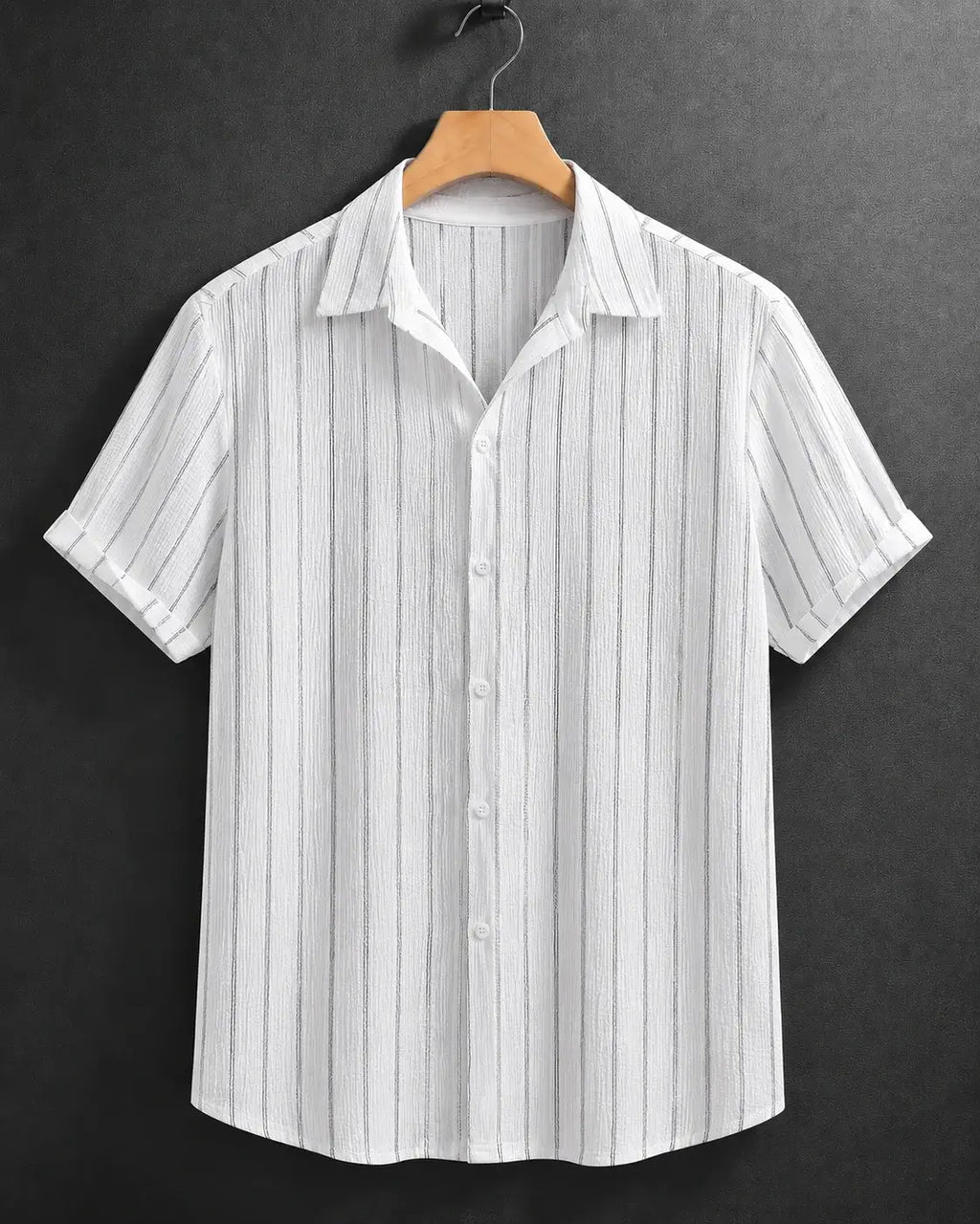 A white short-sleeve button-up shirt with thin vertical gray stripes, hanging on a wooden hanger against a dark gray textured background.