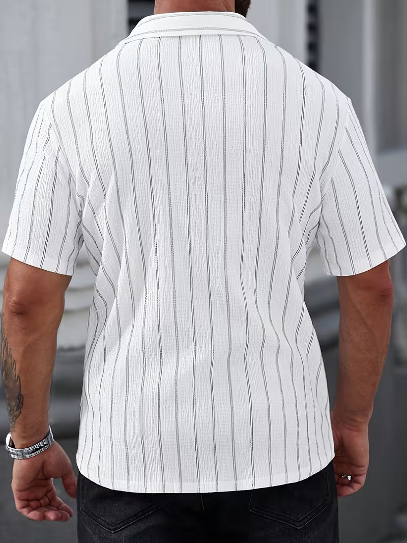 A man viewed from the back wearing a white short-sleeve button-up shirt with thin vertical gray pinstripes and dark jeans.