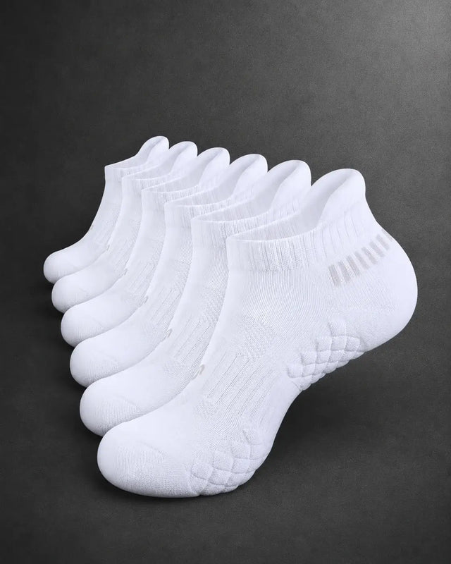 Six pairs of white low-cut ankle socks arranged in a fan shape on a dark gray background.