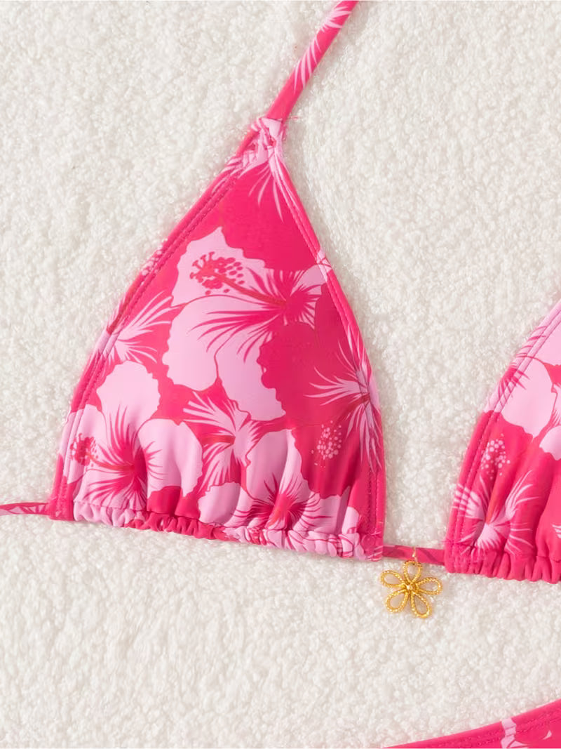 Pink floral bikini set on a textured white background