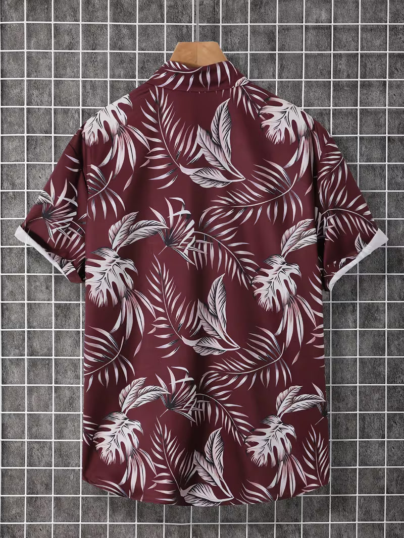 A short-sleeve button-up shirt with a white tropical palm leaf pattern on a deep burgundy background, displayed on a wooden hanger against a gray grid backdrop.